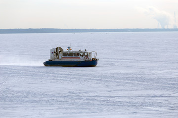 Naklejka premium Boat hovercraft on white ice snow in winter.