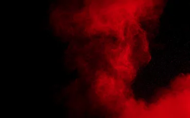 Rote Farbpulverexplosion auf schwarzem Hintergrund. Einfrieren der Bewegung roter Staubpartikel, die spritzen. © Pattadis