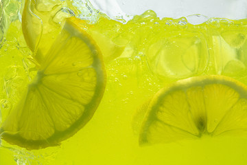 Close up view of the lemon slices in lemonade background. Texture of cooling sweet summer's drink...