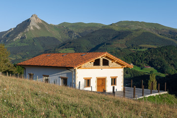 Basque farmhouse in Goierri with Txindoki mountain as background, Basque Country, Spain