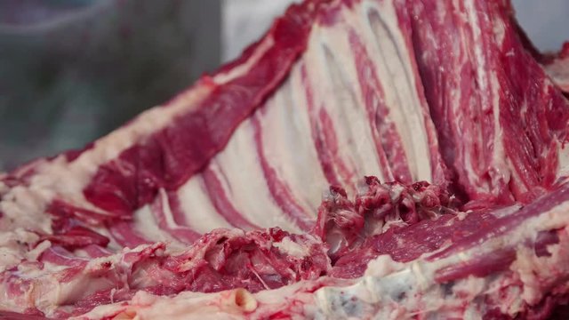 Farmer butchering a whole lamb, cutting lamb ribs and drying the meat 