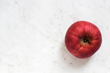 red withered Apple on wooden table.