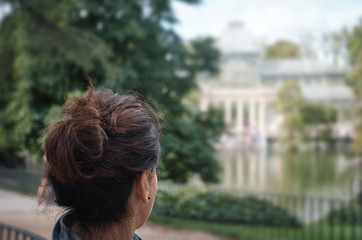 woman looking at Palacio de Cristal, The Crystal Palace - Madrid Spain.