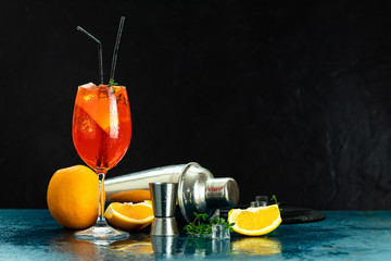 Cocktail aperol spritz in big wine glass with water drops on dark background. Summer alcohol...