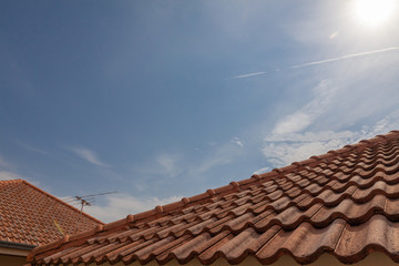 roof top on sky background. Close up of brown clay roof tiles. Red old dirty roof. Old roof tiles. Construction equipment build a house.