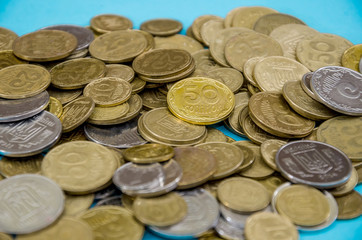 a lot of Ukrainian coins on a blue background. Close-up.