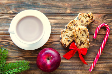 A cup of hot chocolate and traditional Christmas cake stollen on brown rustic background. Top view. Winter tasty backing. 