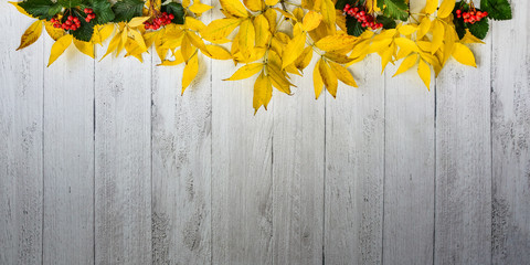 Yellow autumn leaves on a wooden background