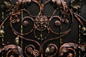 Forged gate with a door handle in the form of a lion's head