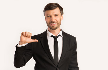 Business Guy Pointing Thumbs At Himself, White Background, Studio Shot