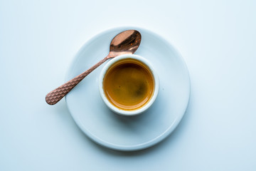 Espresso in a cup and plate with a copper spoon