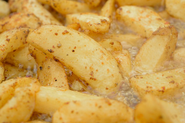 The moment of cooking potatoes with natural seasonings in sunflower oil