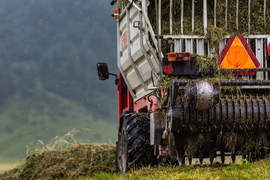truck on the field in the summer alpine mountains during the grass harvest 