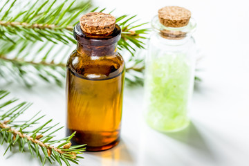 fir branches and spruce bath salt and aroma oil on white table background