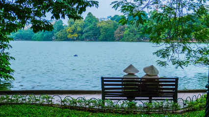 Two women talk at the lake in Hanoi Vietnam