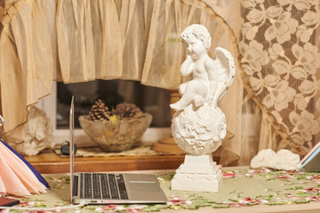sculpture of an angel and laptop