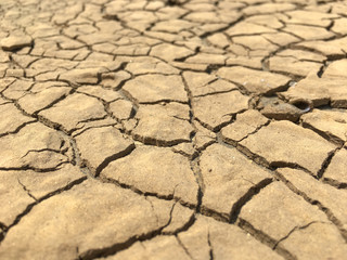 Closeup weathered texture and background of arid cracked ground. Broken dried mud from arid problem.