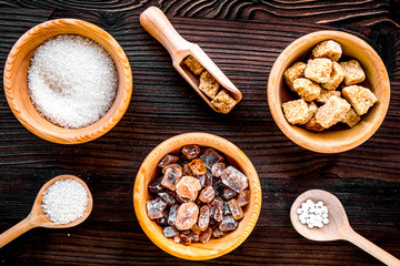 lumps and sanding sugar for sweets on wooden kitchen table background top view
