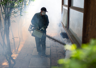 Man work fogging to eliminate mosquito for preventing spread dengue fever