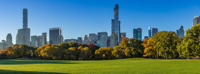 Morning panoramic view of the Central Park Sheep Meadow in Fall. View on the Midtown skyscrapers skyline. Manhattan, New York City