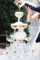 man and woman pour champagne into a slide of champagne