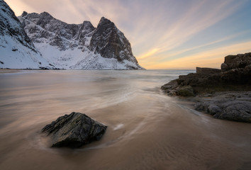 The Lofoten have many beautiful beaches and bays surrounded by the most beautiful mountain peaks with snow in winter. Photo taken during sunset with a slow shutter speed.