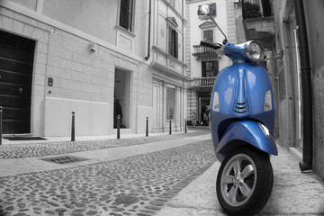 Fototapeta na wymiar kleiner bunter Motorroller in einer Italienischen Altstadt mit Schwarz weißem Hintergrund