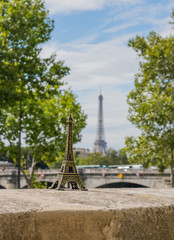 Fototapeta premium Small Eifel tower on the real Eiffel tower background