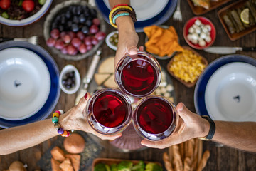 Family dinner for a celebration with red wine and cheers