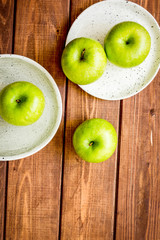 summer food with green apples on wooden background top view