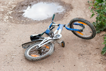 Children's bike fell into a puddle and covered in mud