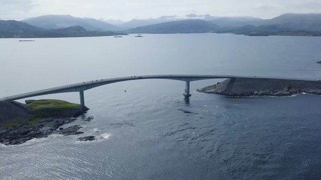 High aerial view of the Atlantic ocean road bridge with cyclist and cars on it, Drone Shot