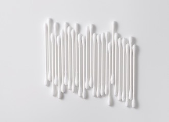 A pile of cotton swabs on a gray background. Space for text
