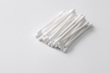 A pile of cotton swabs on a gray background. Space for text
