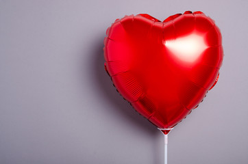 Red balloon shaped heart on gray background, top view. Valentine day concept