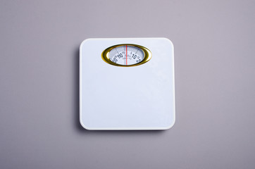 weighing-machine scale on gray background, top view. Weight loss concept