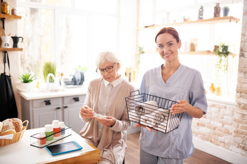 Personal caregiver standing near retired woman