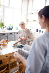 Retired woman in glasses speaking with her caregiver