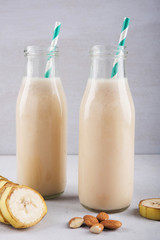 Fresh And Healthy Banana Smoothie In A Bottle With Almond And Sliced Banana