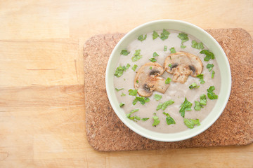 Cream of champignons soup with parsley and croutons, on a wooden background. Hot dish. Top view, food.
