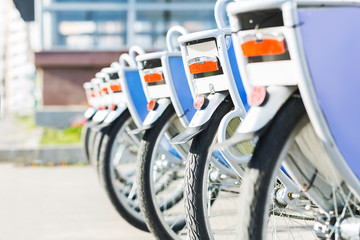 Bicycles for rent in city, close up of wheels outdoor