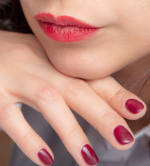 Naklejka premium Girl's hand with red manicure and red lips