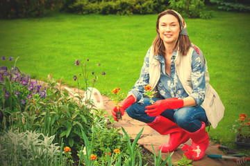 smiling woman in kerchief and red boots planting flowers