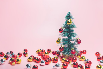 Christmas festival concepts ideas with cute pine tree and red ball ornament on pastel color background.