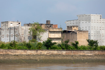 Brutalist industrial architecture along the Saigon River in Vietnam. Buildings are made from concrete slabs with few if any windows