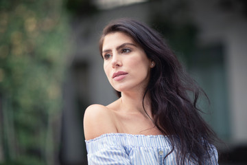 A portrait of a lovely romantic young woman outdoors, inspiringly looking forward