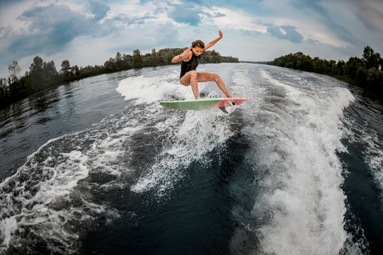 Girl wakesurfer jumps with the surf board