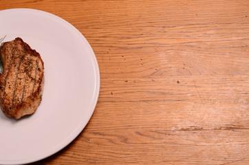 Large piece of rare prime rib with cut vegetables and a baked potato