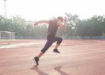 Sprinter leaving starting blocks on the running track. Explosive start.