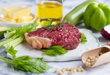 Meat, vegetables and oil on marble background.  Keto diet concept. Low carb and healthy fats. Closeup